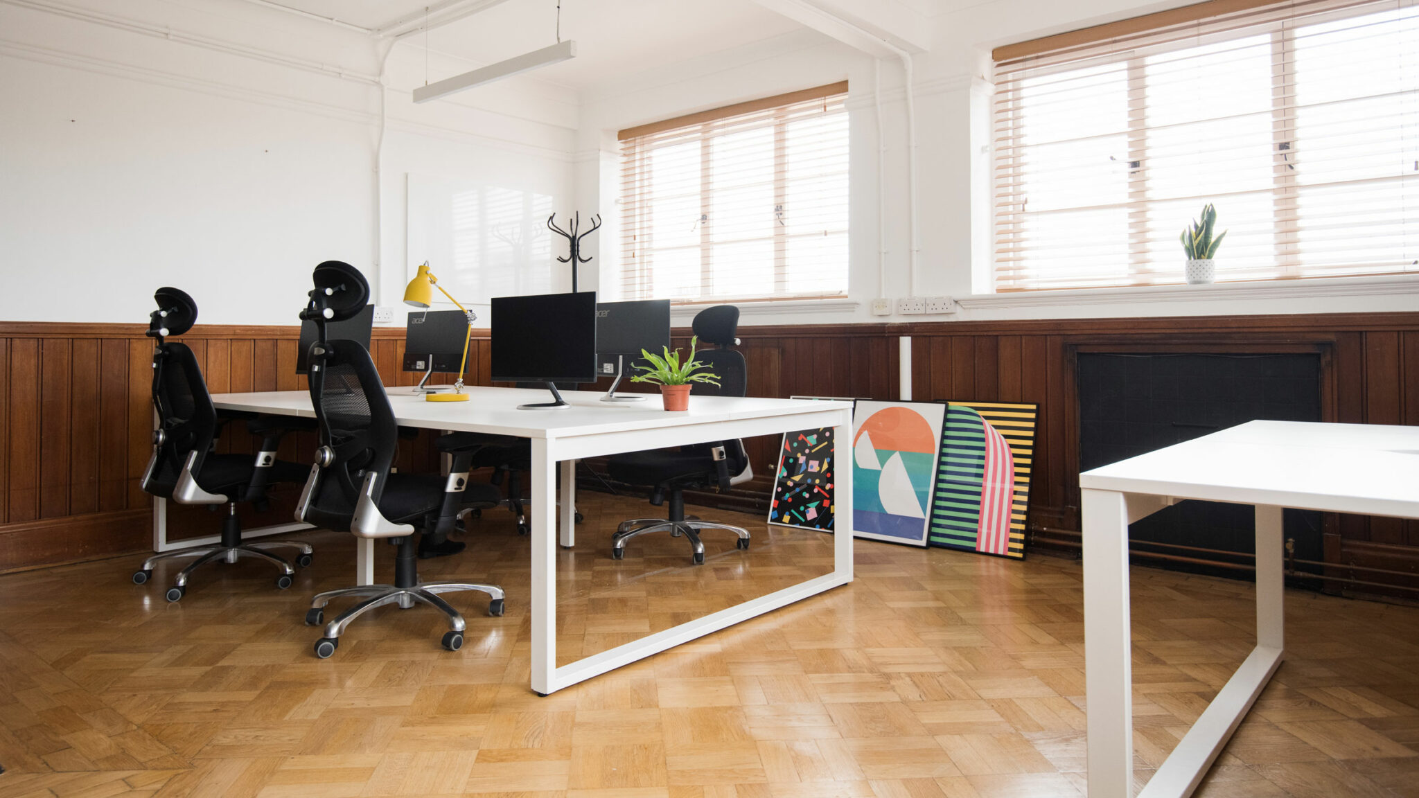 Office space with a white table and parquet floor